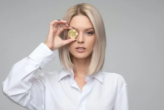 Titelbild für Blogbeitrag Kryptowährung für Einsteiger erklärt, Frau hält sich Bitcoin vor ihr Auge