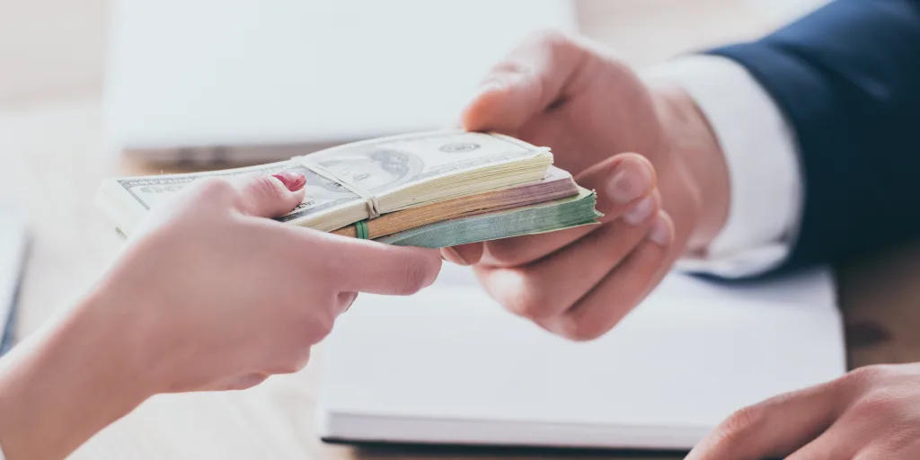 abgeschnittene Aufnahme eines Managers, der Geld von einem Kunden im Büro entgegennimmt