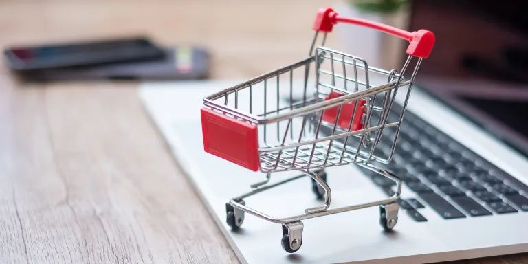 Einkaufswagen auf dem Laptop im Büro zu Hause. Geschäft, E-Business, Technologie, E-Commerce, digitales Banking und Online-Zahlungskonzept