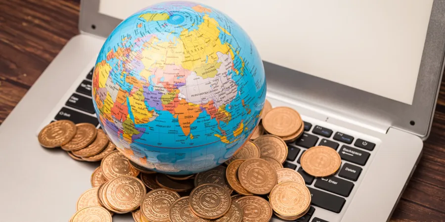 Closeup of the globe's model with coins on the laptop.
